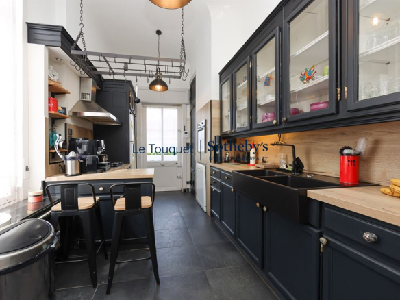 Cuisine moderne d'une villa à Wimereux avec meubles en bois et équipements contemporains.