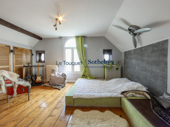 Chambre d'une villa balnéaire à Wimereux avec un lit et des instruments de musique.