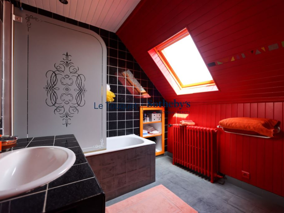 Salle de bain moderne avec baignoire, lavabo et décor rouge vif.