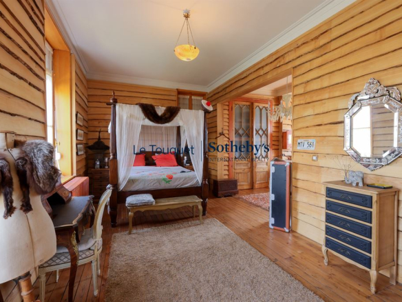 Chambre d'une villa balnéaire à Wimereux avec murs en bois et mobilier vintage.