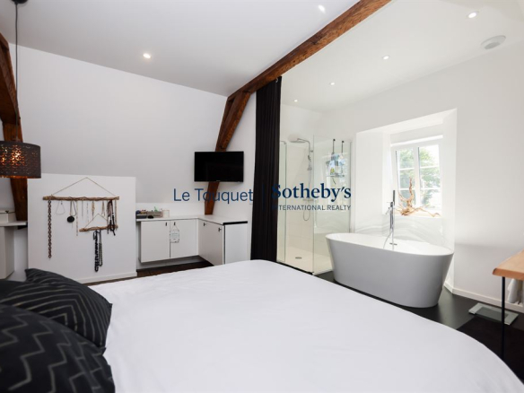 Chambre d'un hôtel particulier rénové du XVIIIème siècle à Montreuil-sur-Mer, avec baignoire et décoration moderne.