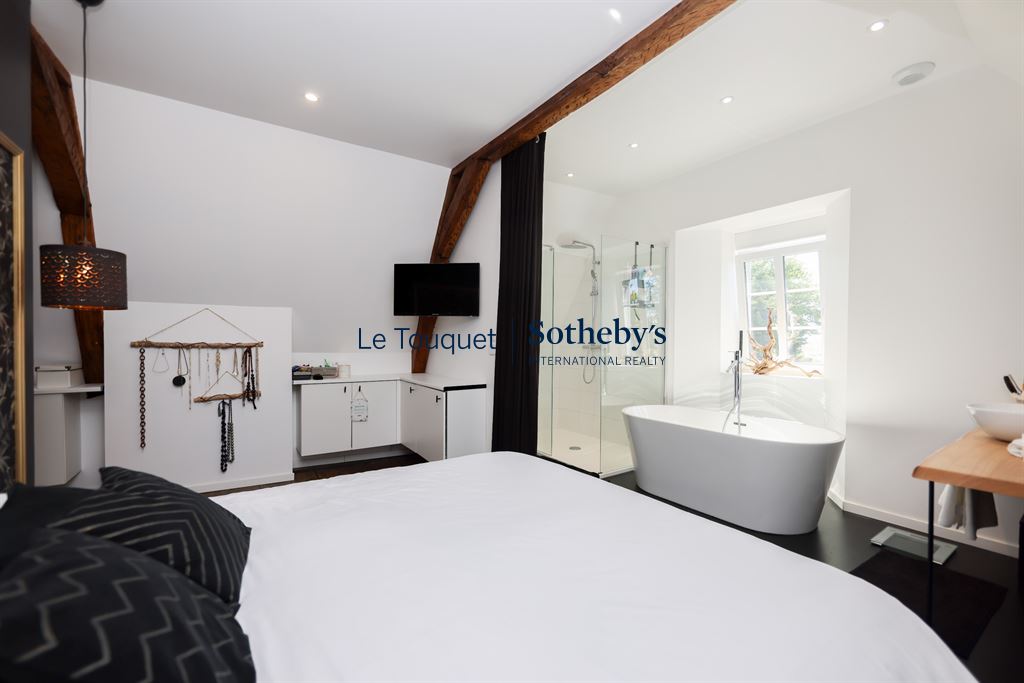 Chambre d’hôtel particulier à Montreuil-sur-Mer Chambre d'un hôtel particulier rénové du XVIIIème siècle à Montreuil-sur-Mer, avec baignoire et décoration moderne.
