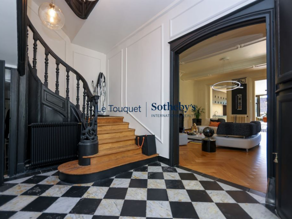 Intérieur d'un hôtel particulier du XVIIIème siècle à Montreuil-sur-Mer, avec un escalier en bois et un salon lumineux.