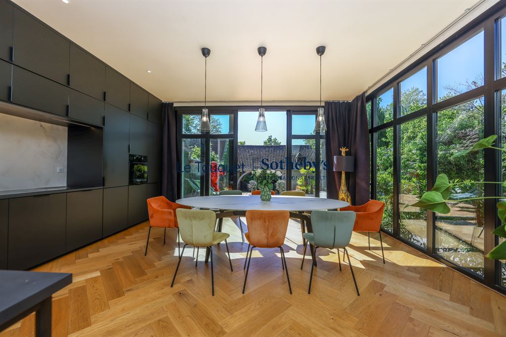 Salle à manger d’un hôtel particulier du XVIIIème siècle Salle à manger moderne avec grandes fenêtres et mobilier coloré dans un hôtel particulier rénové.