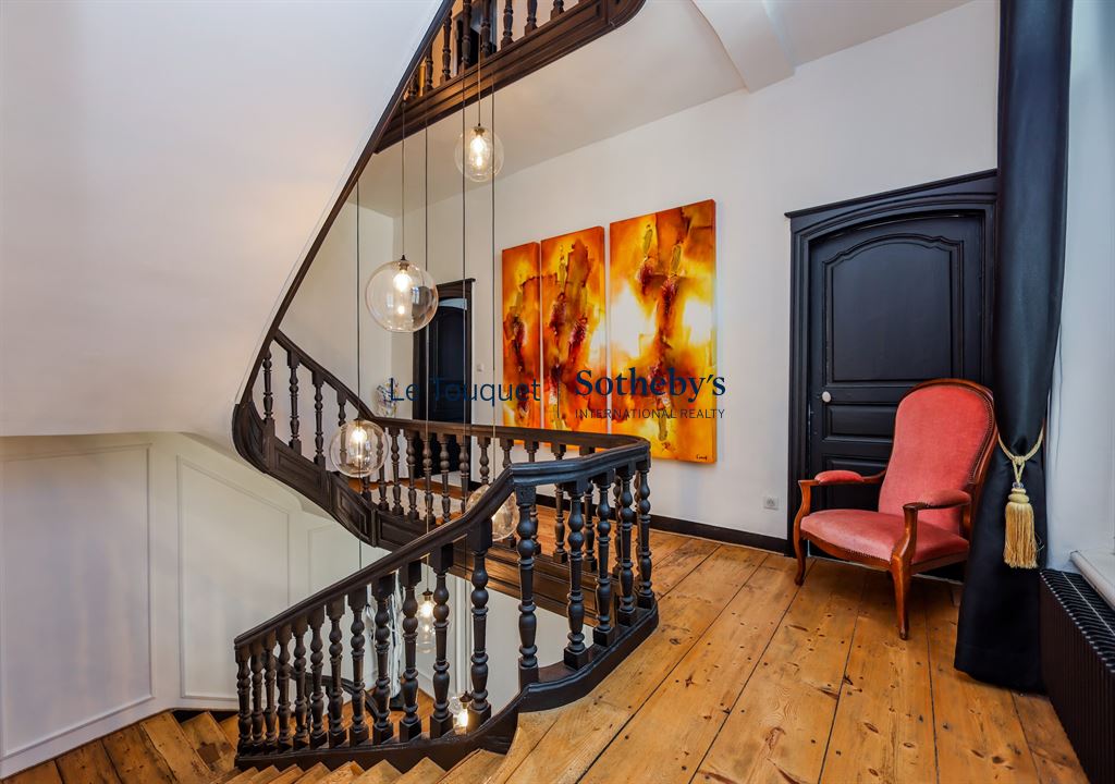 Escalier d’un hôtel particulier à Montreuil-sur-Mer Escalier en bois avec lampes suspendues et fauteuil rouge dans un hôtel particulier du XVIIIème siècle à Montreuil-sur-Mer.