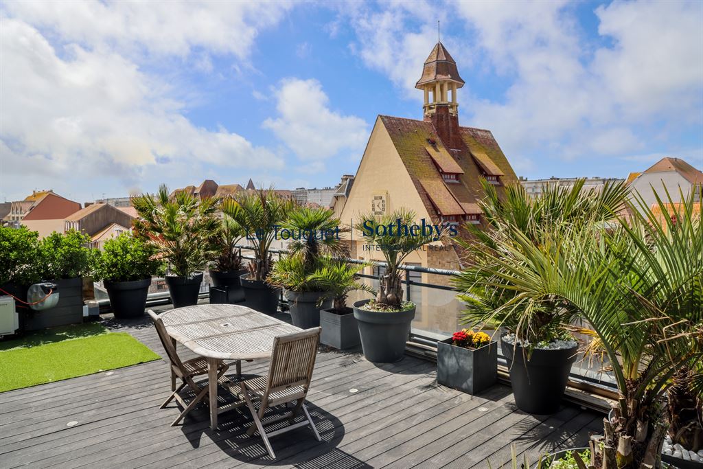 Penthouse avec roof-top au Touquet Terrasse d'un penthouse avec vue sur la ville du Touquet, entourée de plantes et mobilier extérieur.