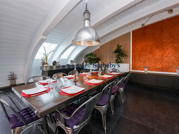 Salle à manger d'un duplex avec table dressée et décoration moderne.