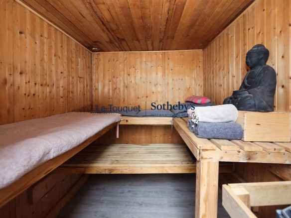 Intérieur d'un sauna en bois avec des serviettes et une statue de Bouddha.