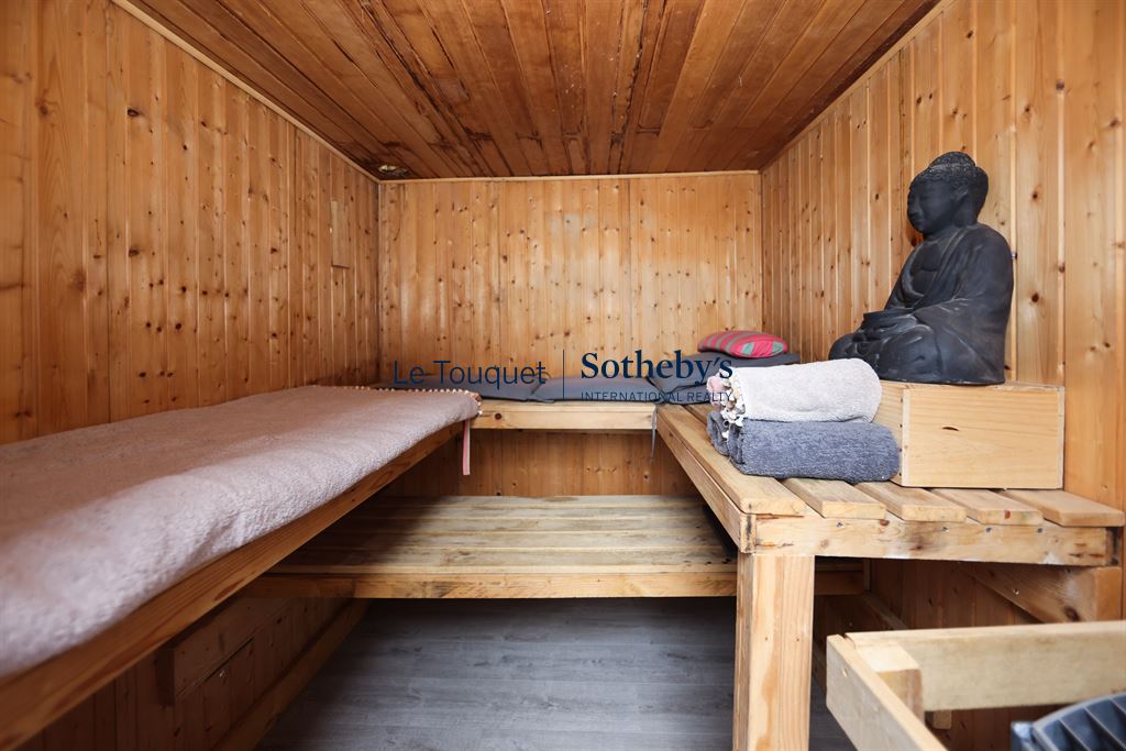 Sauna en bois Intérieur d'un sauna en bois avec des serviettes et une statue de Bouddha.