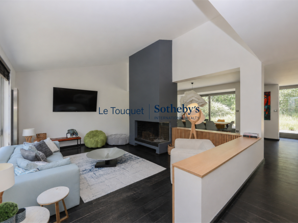 Interior of a contemporary villa with living room, fireplace and open kitchen.