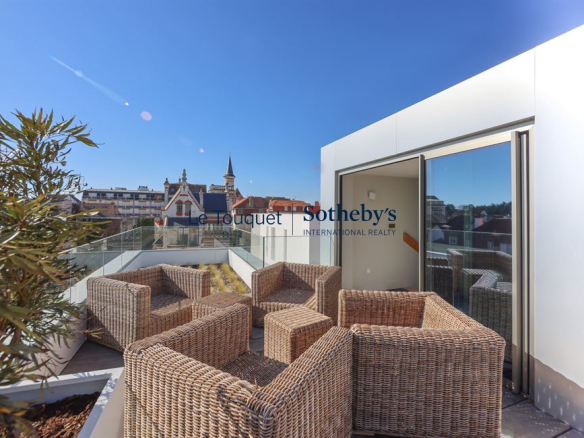 Terrasse d'une villa moderne avec mobilier en rotin, vue sur Le Touquet-Paris-Plage.