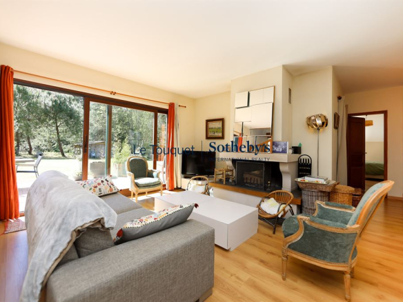 Interior of a house with a bright living room, armchairs and a fireplace.