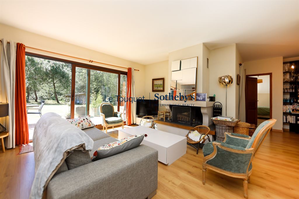Interior of a house with a bright living room, armchairs and a fireplace.