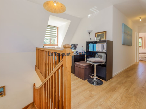Interior of a house with a wooden staircase and an office, bright and welcoming.