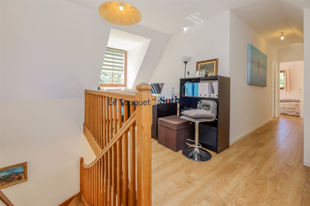 Interior of a house with a wooden staircase and an office, bright and welcoming.