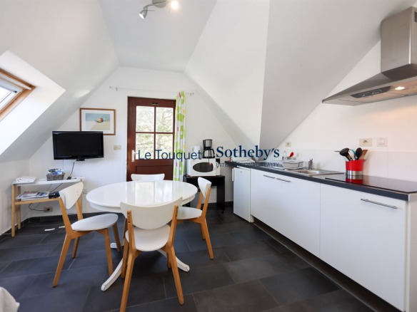 Modern kitchen with round table and white chairs in a house in Harnelot.
