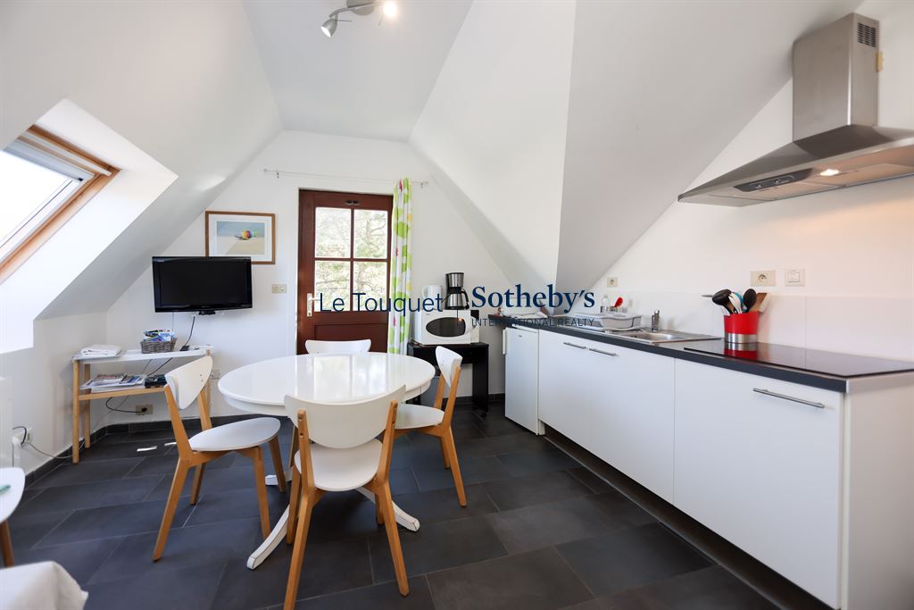 Modern kitchen with round table and white chairs in a house in Harnelot.