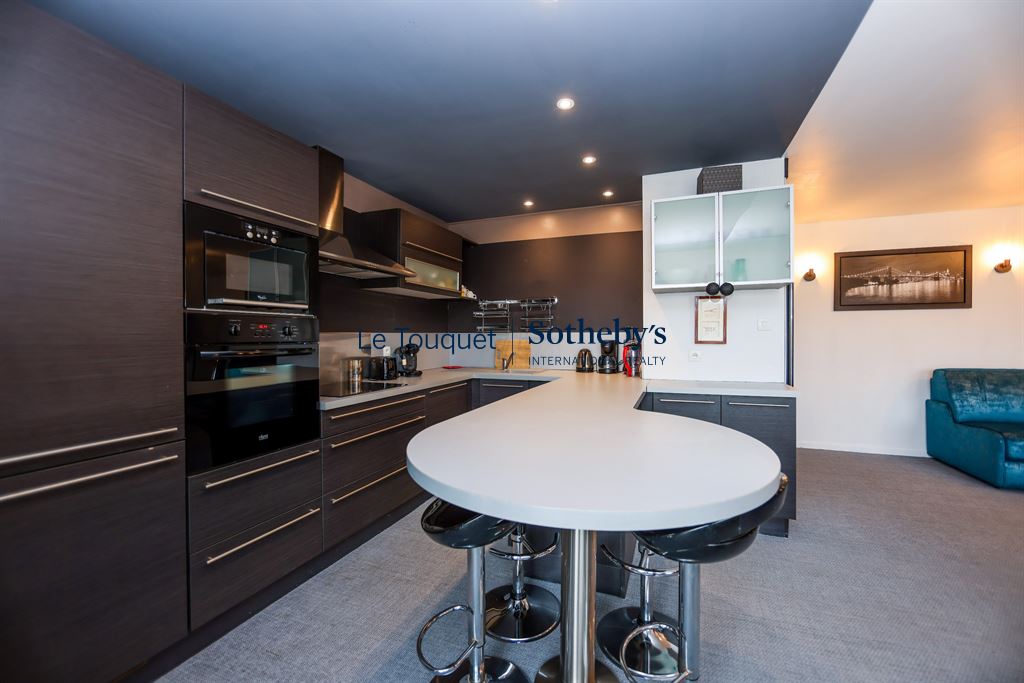 Kitchen of an apartment in Le Touquet Modern kitchen in an apartment in Le Touquet with central island and integrated appliances.