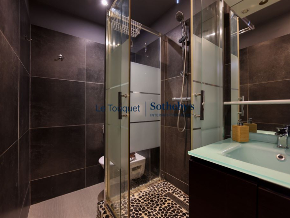 Modern shower room with walk-in shower and sink in an apartment in Le Touquet.