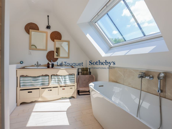 Modern bathroom with bathtub and skylight in a renovated property.