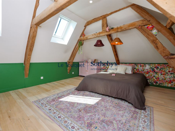 Room in a renovated property with exposed beams and colorful decor.