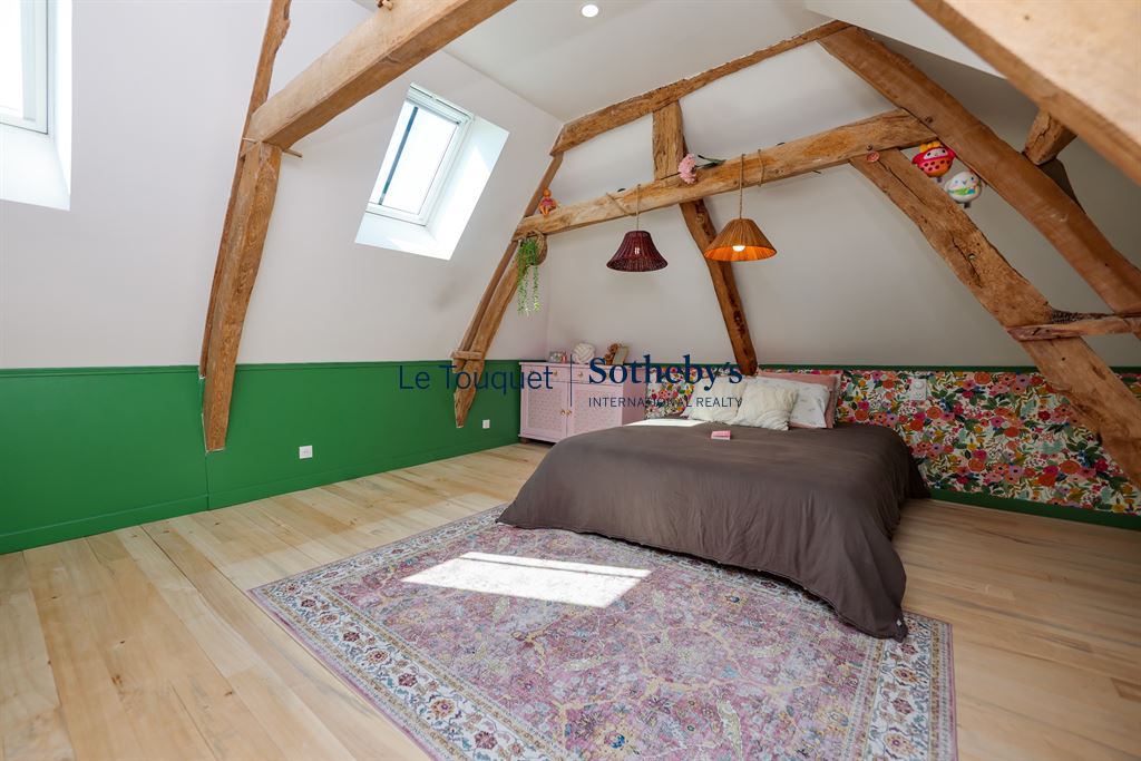 Room in a renovated property with exposed beams and colorful decor.