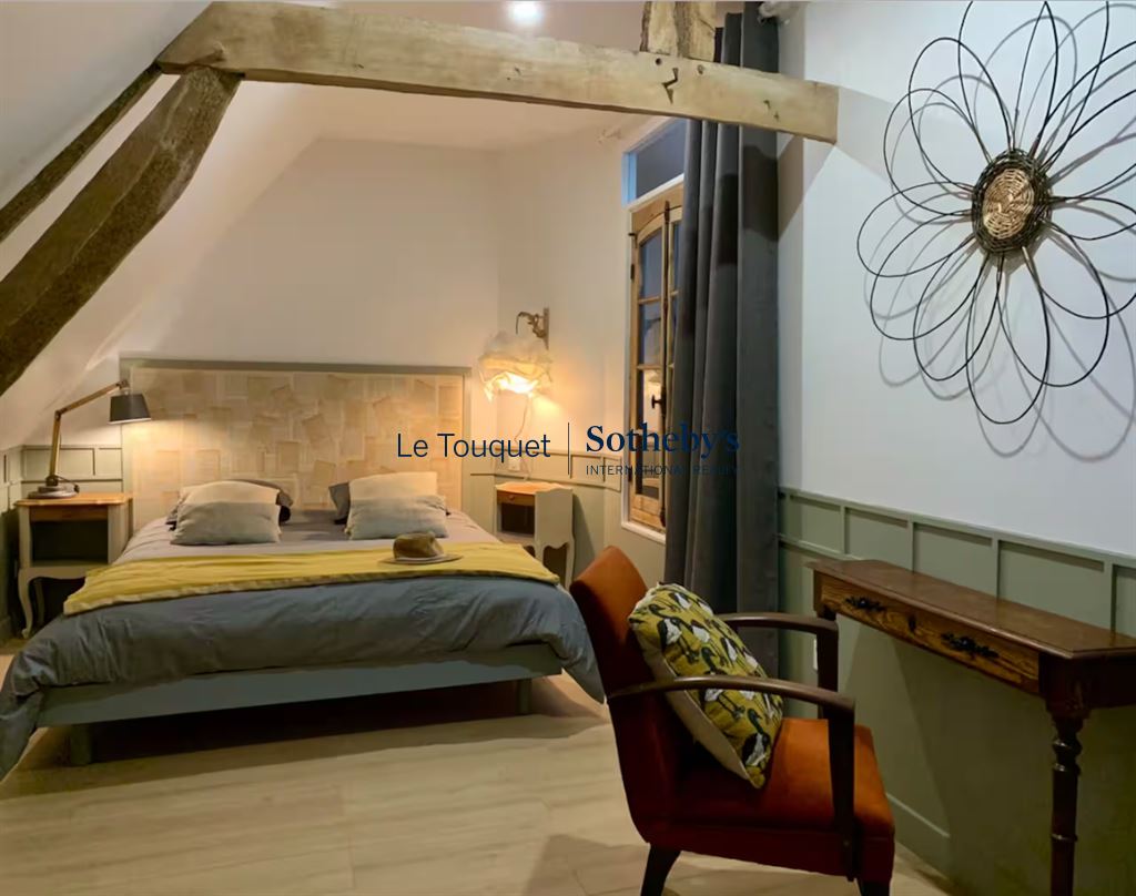 Room in a renovated property with bed, armchair and modern decor.