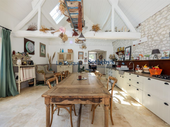 Interior of a renovated property with a large wooden table and decorative elements.
