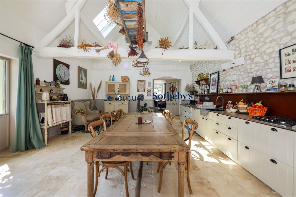 Interior of a renovated property with a large wooden table and decorative elements.