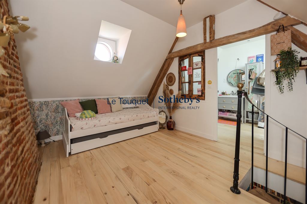 Interior of a renovated cottage with brick walls and a bright living space.