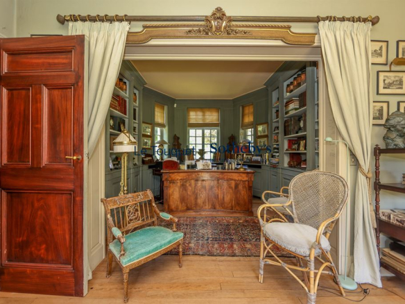 Interior of a historic property with a wooden desk and armchairs, Le Touquet-Paris-Plage.