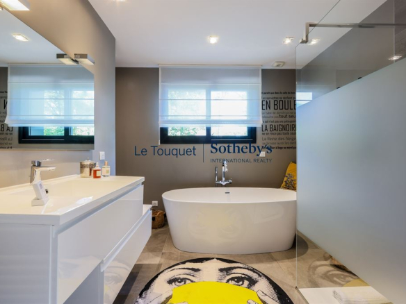 Salle de bain moderne avec baignoire et lavabo, décorée de manière contemporaine.