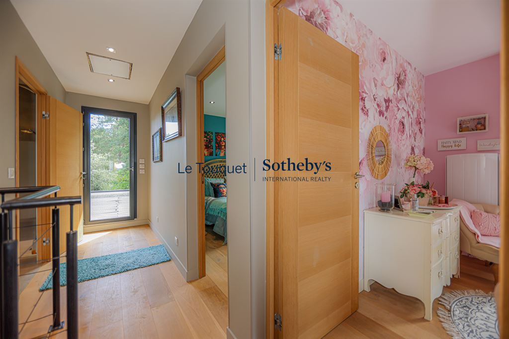 Intérieur d’une villa contemporaine à Stella Plage Intérieur d'une villa contemporaine avec un couloir menant à des chambres et une décoration florale.