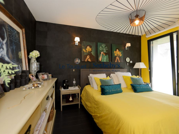 Chambre d'une villa contemporaine avec un lit jaune et des décorations murales modernes.