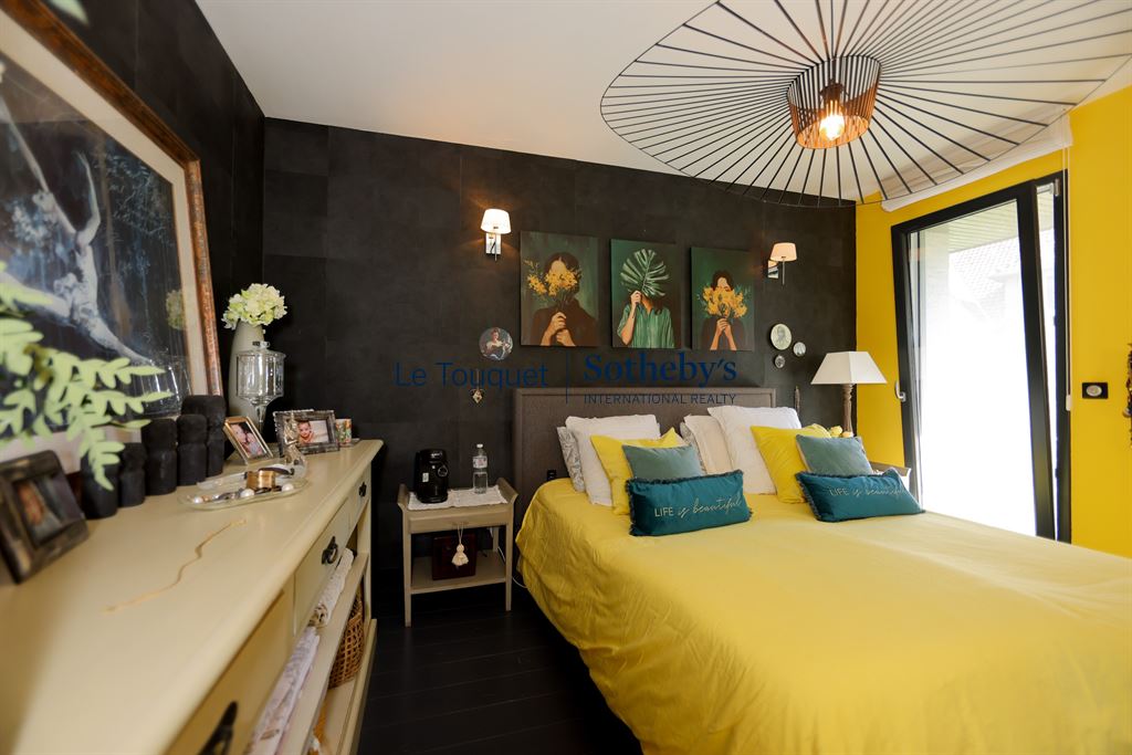 Chambre moderne de villa à Stella Plage Chambre d'une villa contemporaine avec un lit jaune et des décorations murales modernes.