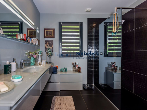 Salle de bain moderne avec lavabo et douche dans une villa contemporaine.