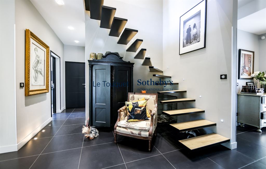 Intérieur d’une villa contemporaine Intérieur d'une villa contemporaine avec un escalier en bois et un coin salon confortable.