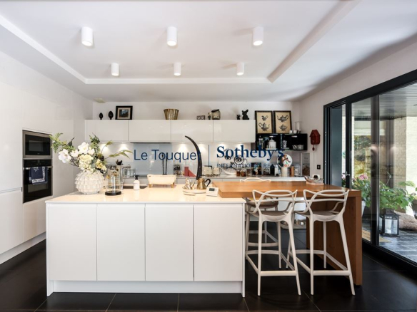 Cuisine moderne et lumineuse d'une villa contemporaine à Stella Plage, avec îlot central et espace de vie ouvert.