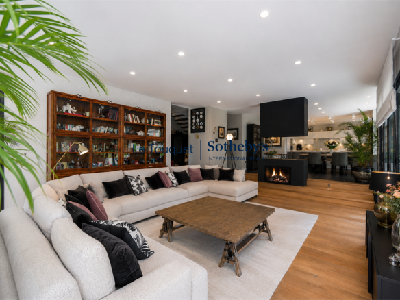 Intérieur d'une villa contemporaine avec un salon spacieux et lumineux, un canapé et une cheminée.