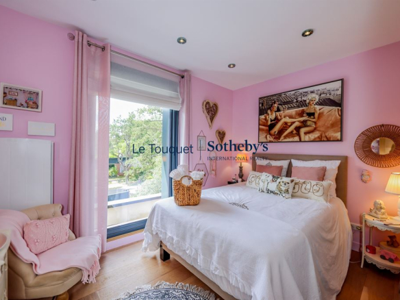 Chambre d'une villa contemporaine à Stella Plage, avec murs roses et lit confortable.
