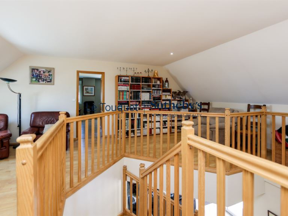 Intérieur d'une villa à Saint-Josse avec un espace de vie lumineux et un balcon en bois.