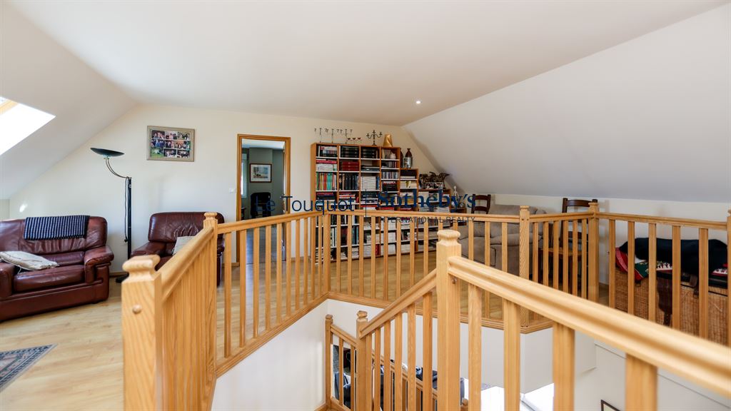 Intérieur d'une villa à Saint-Josse avec un espace de vie lumineux et un balcon en bois.