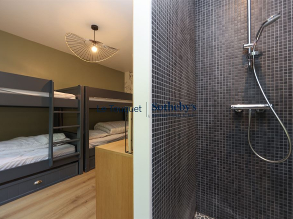 Chambre avec lits superposés et salle de bain attenante dans une villa contemporaine