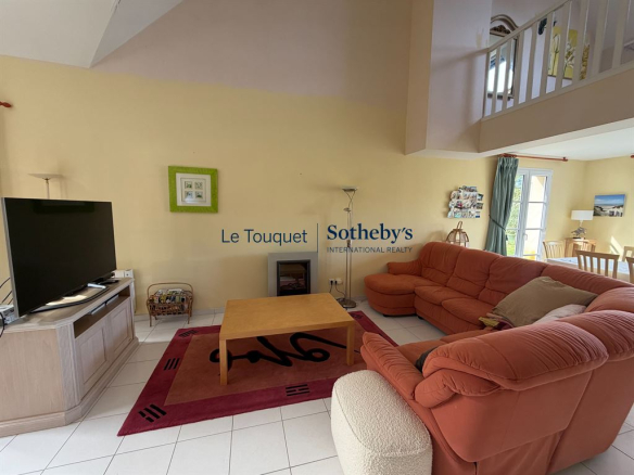 Intérieur d'une villa à Le Touquet-Paris-Plage, salon avec canapé et télévision