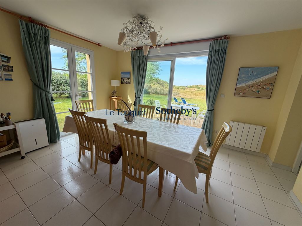 Salle à manger avec vue sur les dunes Salle à manger lumineuse avec vue sur le jardin et les dunes au Touquet-Paris-Plage.