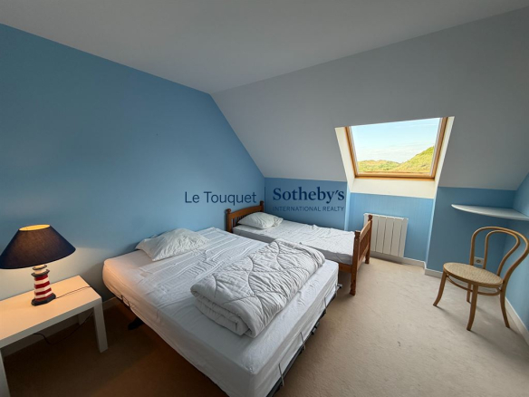 Chambre à coucher avec lits jumeaux et fenêtre sur les dunes au Touquet-Paris-Plage.