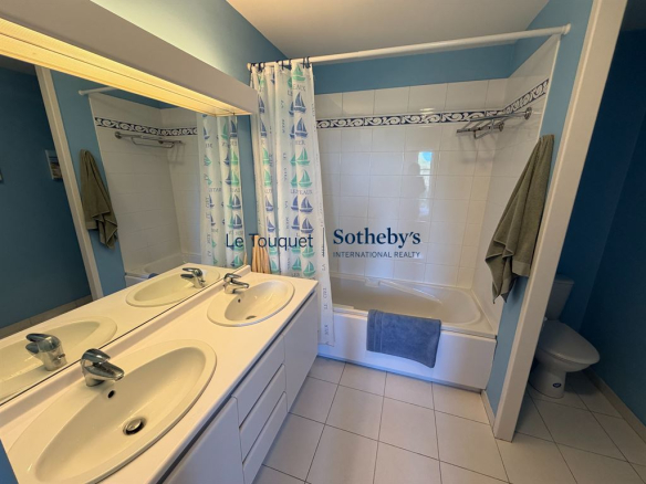 Salle de bain avec baignoire et double vasque dans une villa au Touquet-Paris-Plage.