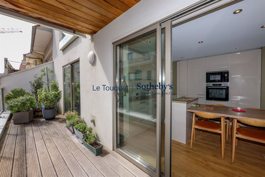 Appartement moderne avec terrasse au Touquet Terrasse d'un appartement moderne avec vue sur une pièce de vie lumineuse et cuisine équipée.