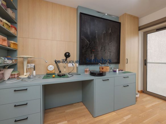 Bureau moderne avec rangements intégrés et accès à un balcon, dans un appartement au Touquet-Paris-Plage.