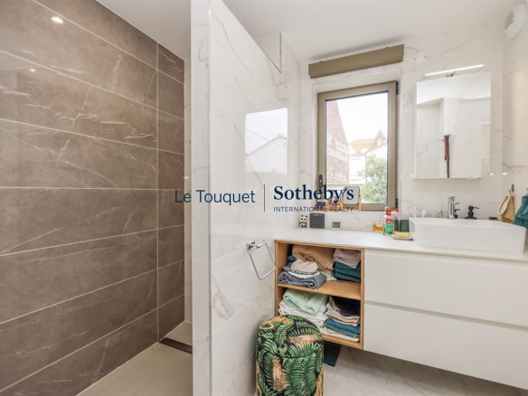 Salle de douche moderne avec douche à l'italienne et meuble de rangement.